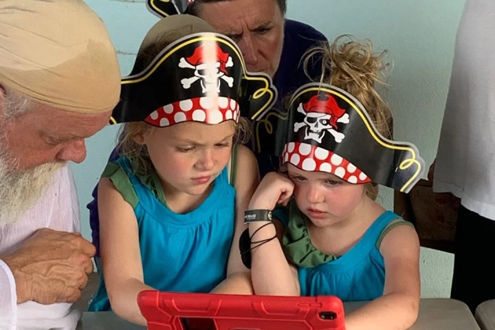 a group of young men sitting next to a little boy wearing a hat