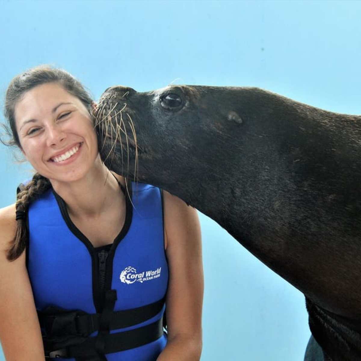 a woman standing in front of a body of water posing for the camera